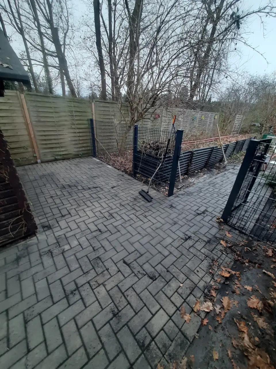 Fertig gepflasterter Tor- und Gartenbereich mit Abzweig zu einem schmalen Verbindungsweg